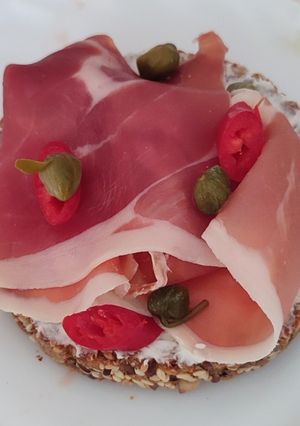 Брускетта з хамоном, крем сиром, каперсами і перцем чілі