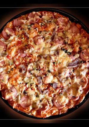 Піца з ковбаскою, беконом і помідорами черрі на листковому тісті