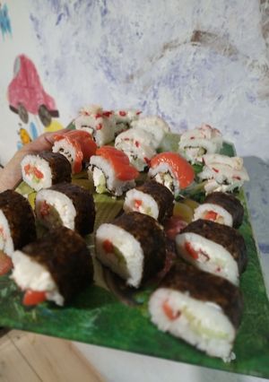 Домашні суші з червоною рибою, м'яким сиром, крабовими паличками у норі