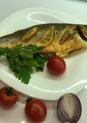Сибас, запечённый с дольками лимона и петрушкой